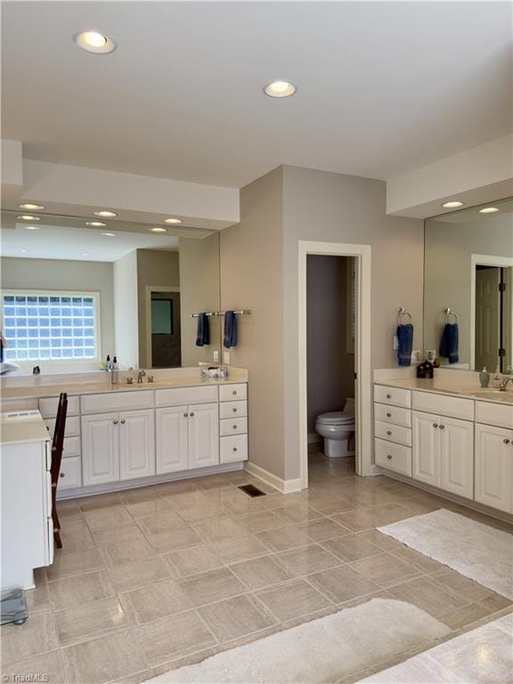 606 Dorado Cir, High Point, NC 27265 - bathroom with two vanities, toilet, recessed lighting, and baseboards