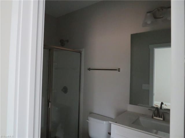 bathroom featuring walk in shower, vanity, and toilet