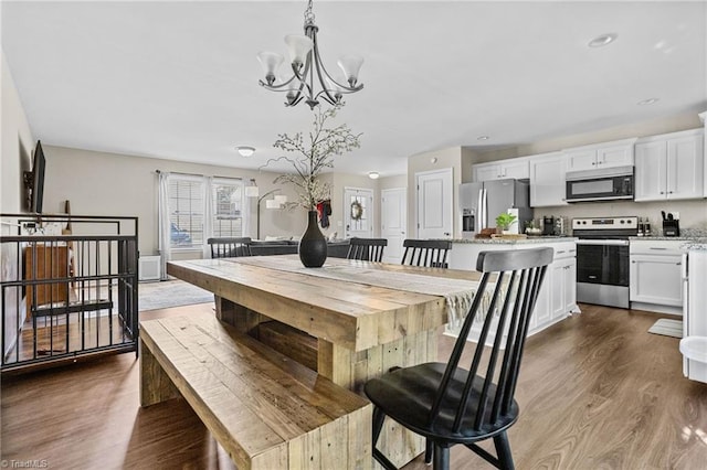 dining room with a notable chandelier and dark hardwood / wood-style flooring