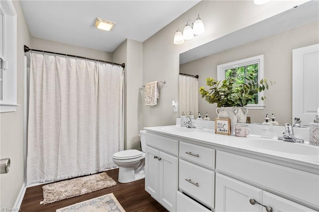 bathroom featuring vanity, curtained shower, hardwood / wood-style flooring, and toilet