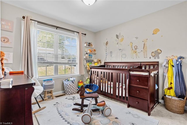 bedroom featuring light colored carpet and a crib