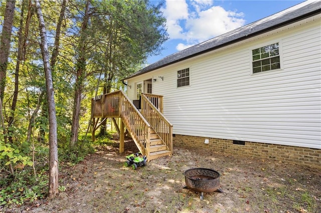 exterior space featuring an outdoor fire pit and a deck