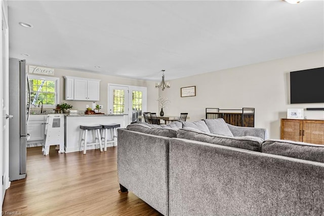 living room featuring a notable chandelier, dark wood-type flooring, and a wealth of natural light