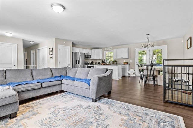 living room with a notable chandelier and dark hardwood / wood-style flooring