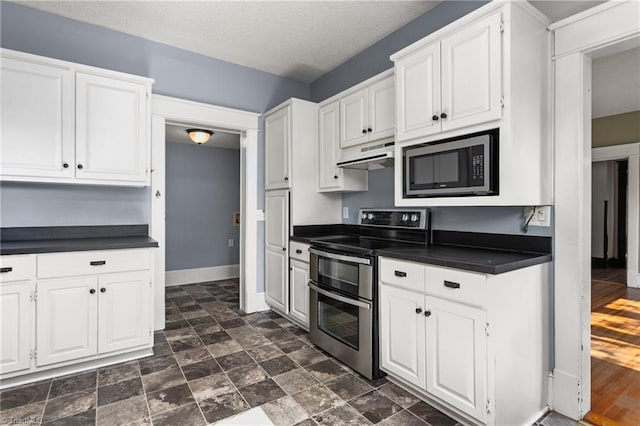 104 E Wilson St, Mebane, NC 27302 - kitchen featuring appliances with stainless steel finishes, dark countertops, under cabinet range hood, white cabinets, and baseboards