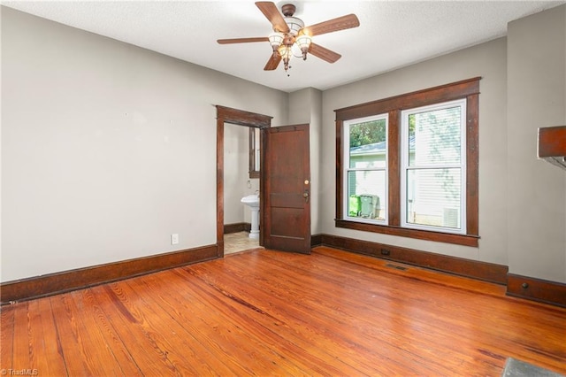 104 E Wilson St, Mebane, NC 27302 - empty room with baseboards, a ceiling fan, and light wood-style floors