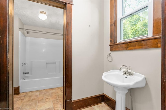 104 E Wilson St, Mebane, NC 27302 - full bath with shower / tub combination, stone finish flooring, baseboards, and a textured ceiling