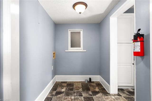104 E Wilson St, Mebane, NC 27302 - laundry area with a textured ceiling, baseboards, washer hookup, and dark stone finish floors