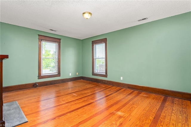 104 E Wilson St, Mebane, NC 27302 - spare room featuring wood finished floors, healthy amount of natural light, baseboards, and a textured ceiling