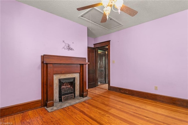 104 E Wilson St, Mebane, NC 27302 - unfurnished living room featuring ceiling fan, wood finished floors, attic access, baseboards, and a fireplace with flush hearth