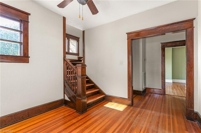 104 E Wilson St, Mebane, NC 27302 - spare room with wood finished floors, baseboards, a ceiling fan, and stairway