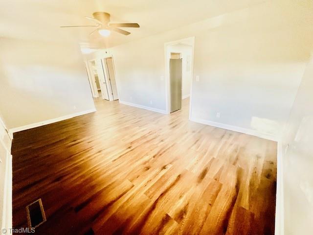 unfurnished room with wood-type flooring and ceiling fan