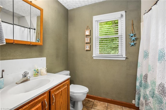 bathroom featuring a shower with shower curtain, toilet, vanity, baseboards, and tile patterned floors