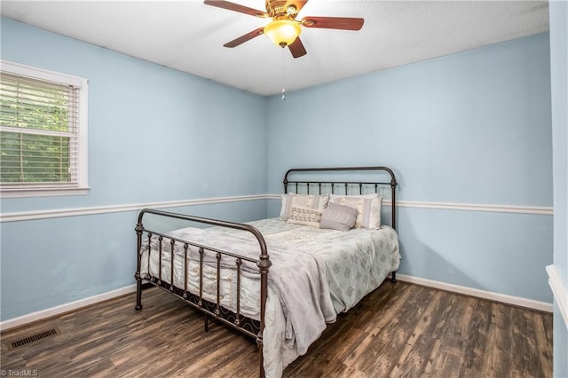 bedroom with visible vents, ceiling fan, baseboards, and wood finished floors