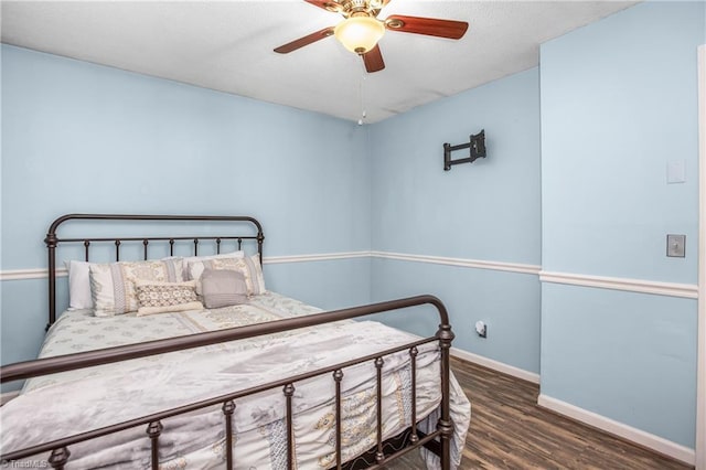 bedroom with ceiling fan, a textured ceiling, baseboards, and wood finished floors