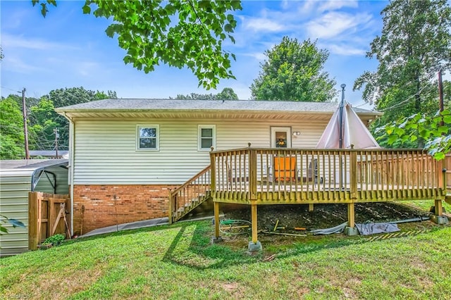 back of property featuring brick siding, a lawn, and a wooden deck