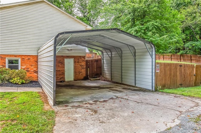 view of parking / parking lot featuring fence and a carport