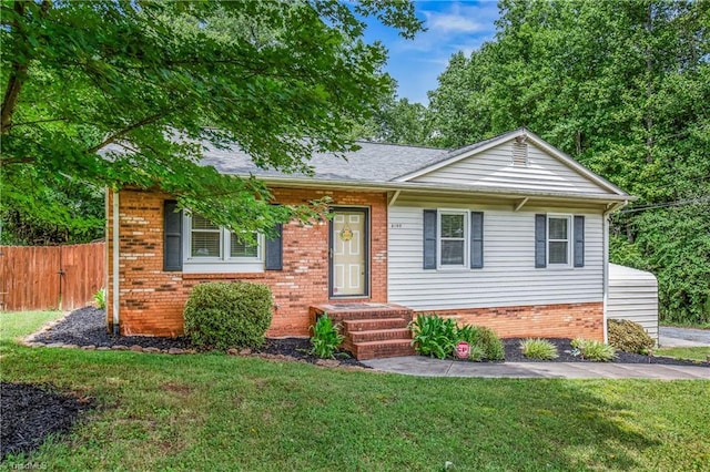 view of front of property with a front lawn, fence, and brick siding