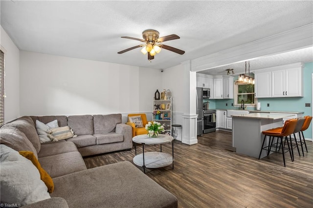 living room featuring dark wood-style floors, a textured ceiling, and a ceiling fan