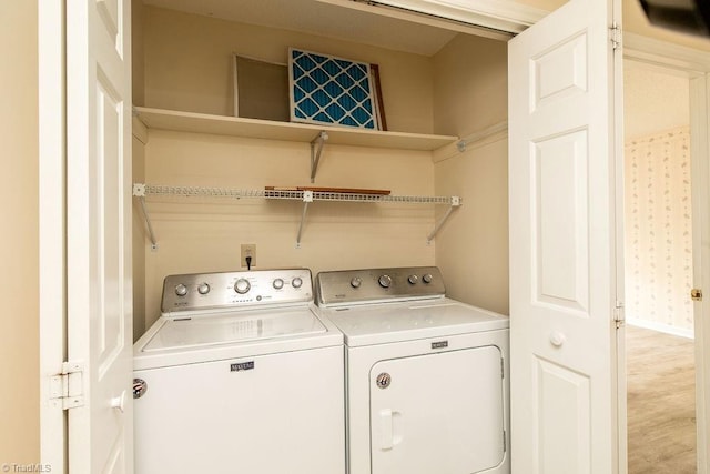 laundry area featuring light hardwood / wood-style floors and washing machine and dryer