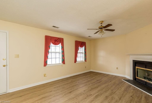 unfurnished living room with ceiling fan, wood-type flooring, and a textured ceiling