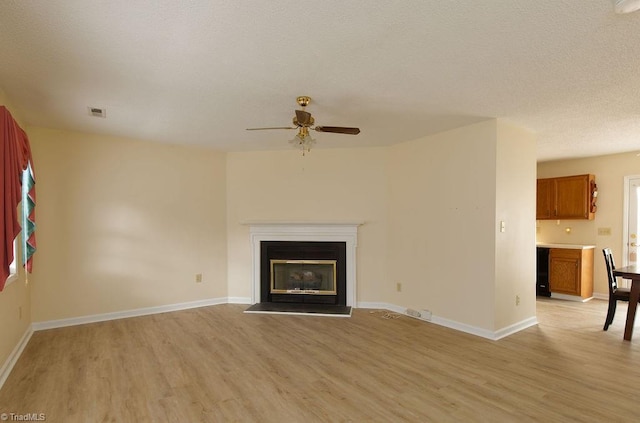 unfurnished living room featuring ceiling fan and light hardwood / wood-style flooring