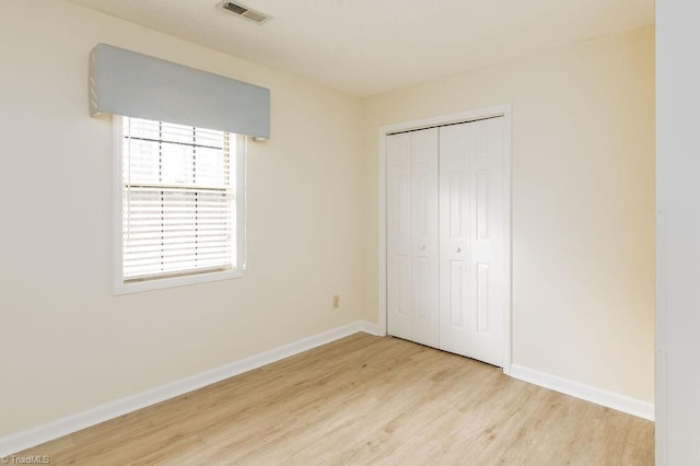 unfurnished bedroom featuring a closet and light hardwood / wood-style flooring