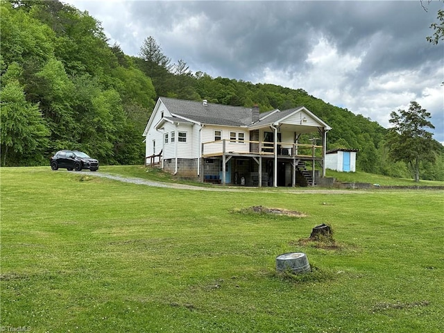 813 Blevins Store Rd, Mount Airy, NC 27030 - back of property featuring a deck, a lawn, a shed, and an outbuilding