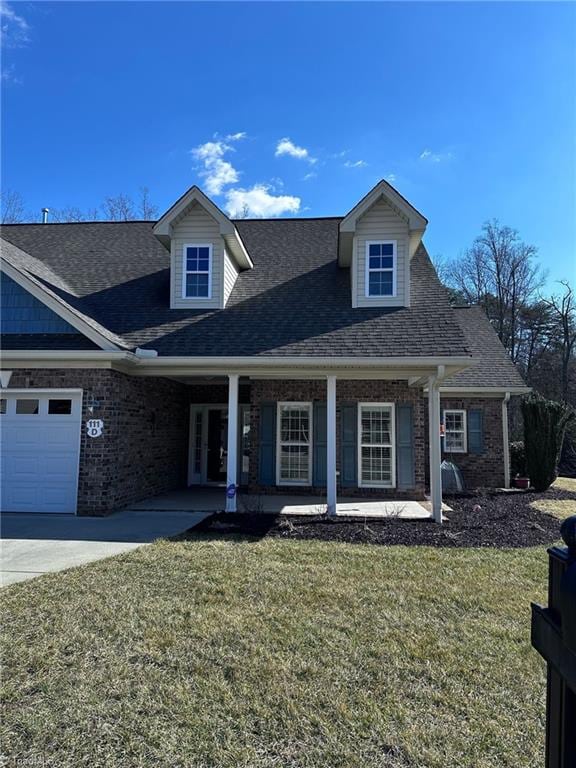 view of front of property with a porch, a garage, and a front yard