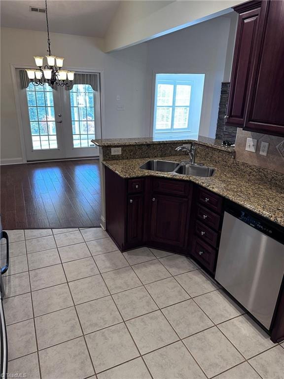 kitchen featuring light stone countertops, stainless steel dishwasher, kitchen peninsula, and decorative light fixtures