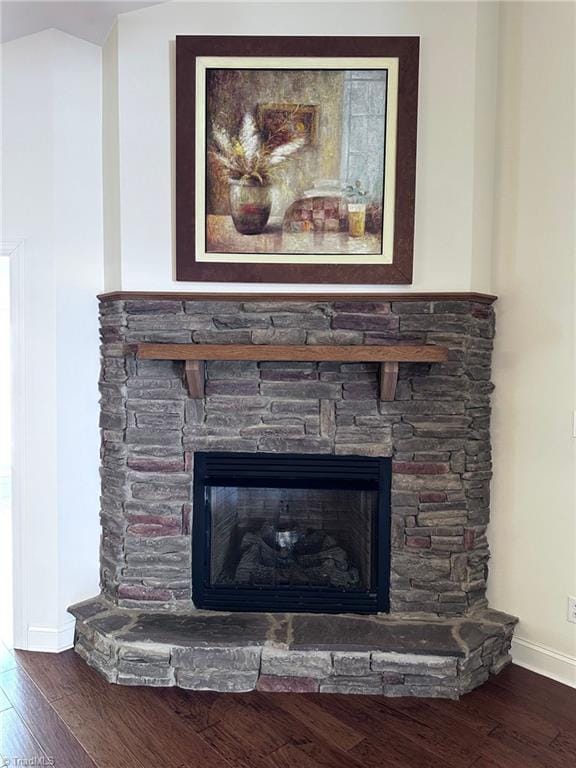 details with a stone fireplace and hardwood / wood-style floors