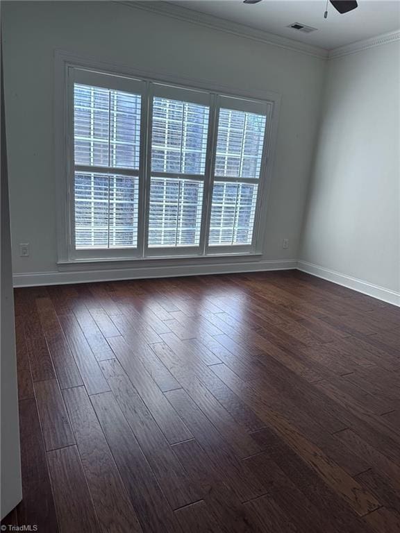 unfurnished room with ceiling fan, crown molding, a wealth of natural light, and dark wood-type flooring