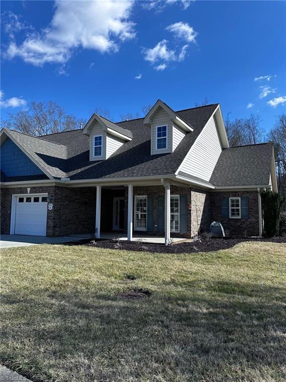 view of front of property with a garage, a front yard, and covered porch