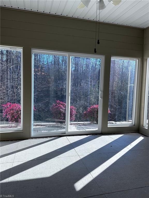 unfurnished sunroom featuring ceiling fan