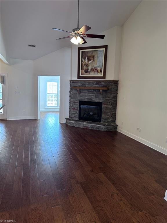 unfurnished living room with dark hardwood / wood-style floors, ceiling fan, a stone fireplace, and high vaulted ceiling