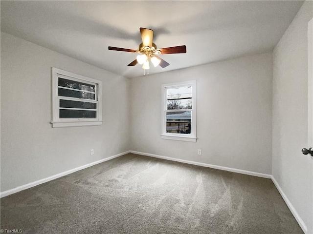 spare room featuring ceiling fan and dark carpet