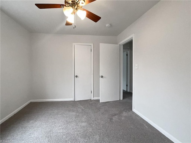 unfurnished bedroom with dark colored carpet and ceiling fan