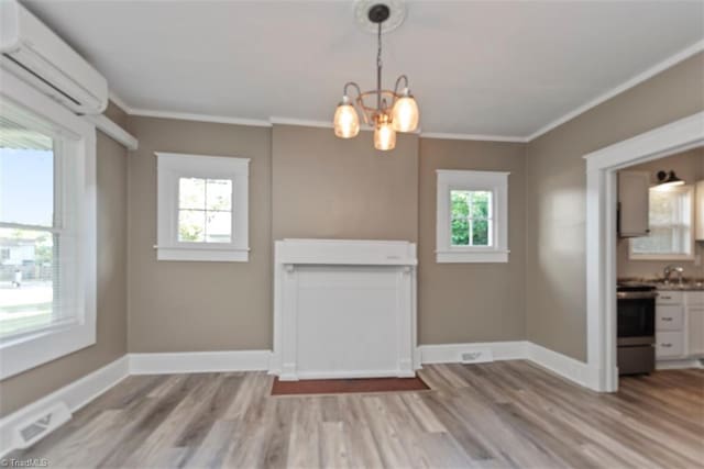712 Englewood St, Greensboro, NC 27403 - unfurnished living room with an AC wall unit, a chandelier, light wood finished floors, crown molding, and baseboards