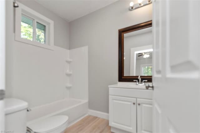 712 Englewood St, Greensboro, NC 27403 - bathroom with toilet, vanity, wood finished floors, tub / shower combination, and baseboards