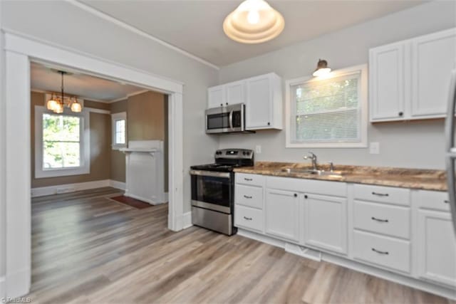 712 Englewood St, Greensboro, NC 27403 - kitchen with appliances with stainless steel finishes, a sink, white cabinetry, a chandelier, and light wood-style floors