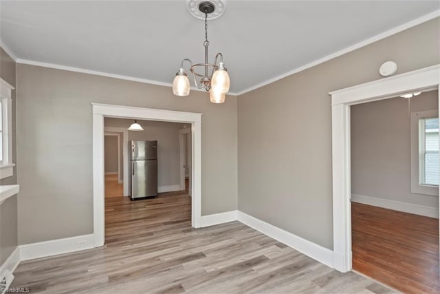 712 Englewood St, Greensboro, NC 27403 - unfurnished dining area with light wood-style floors, ornamental molding, a chandelier, and baseboards