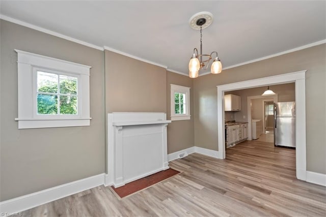 712 Englewood St, Greensboro, NC 27403 - unfurnished dining area featuring light wood finished floors, crown molding, plenty of natural light, and baseboards