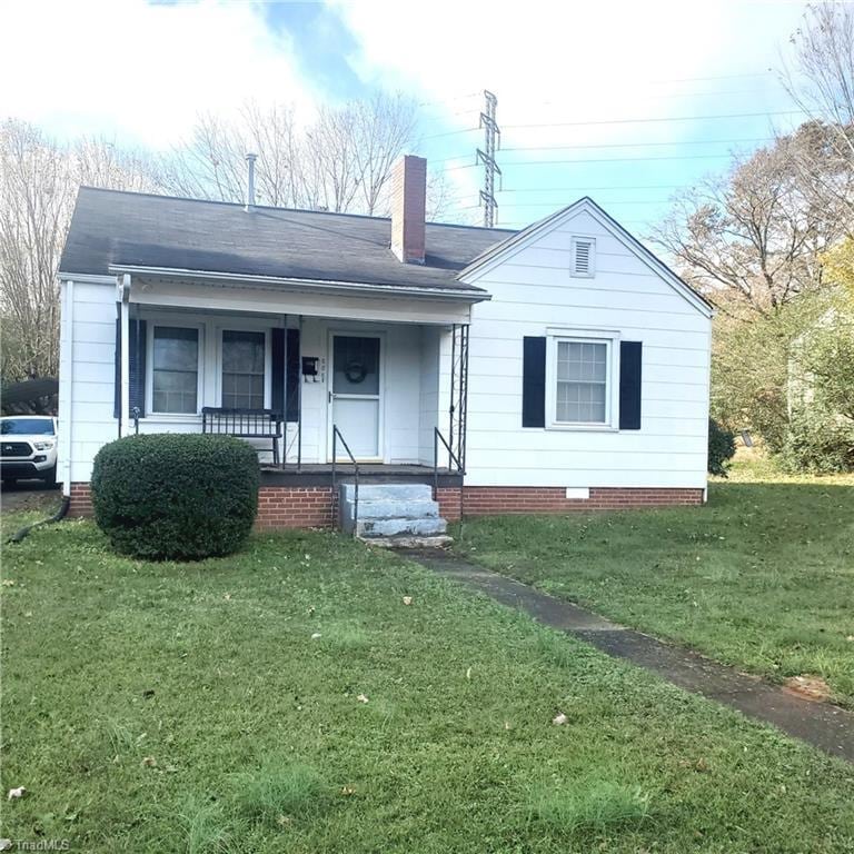 view of front facade with covered porch and a front yard