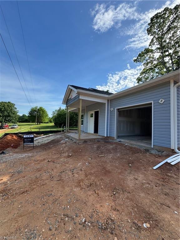 3145 Chapel St, Walkertown, NC 27051 - view of side of property with an attached garage, covered porch, and driveway