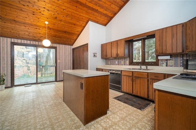 kitchen featuring a kitchen island, hanging light fixtures, stainless steel appliances, light countertops, and a sink