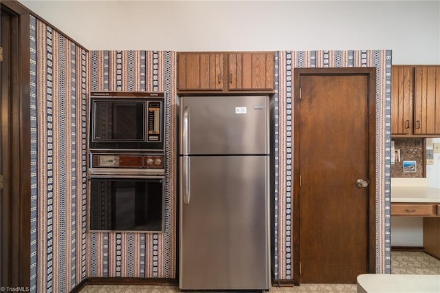 kitchen featuring brown cabinets, appliances with stainless steel finishes, and light countertops