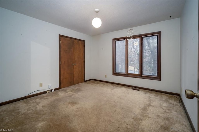 carpeted empty room featuring visible vents and baseboards