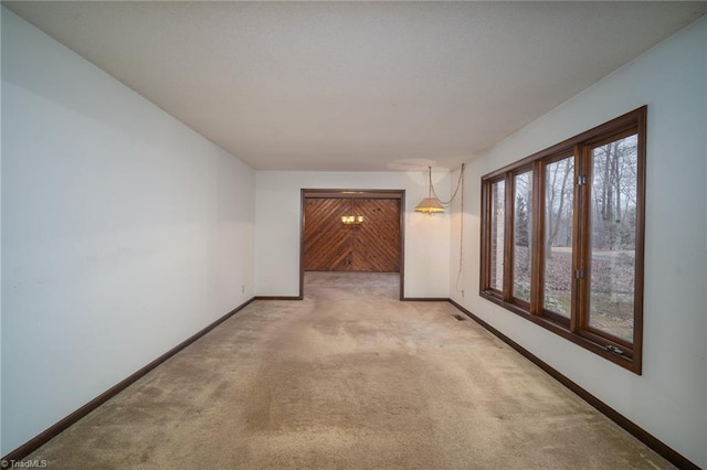 hallway featuring light carpet and baseboards