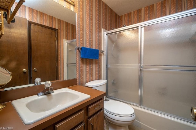 full bath with combined bath / shower with glass door, vanity, toilet, and wallpapered walls