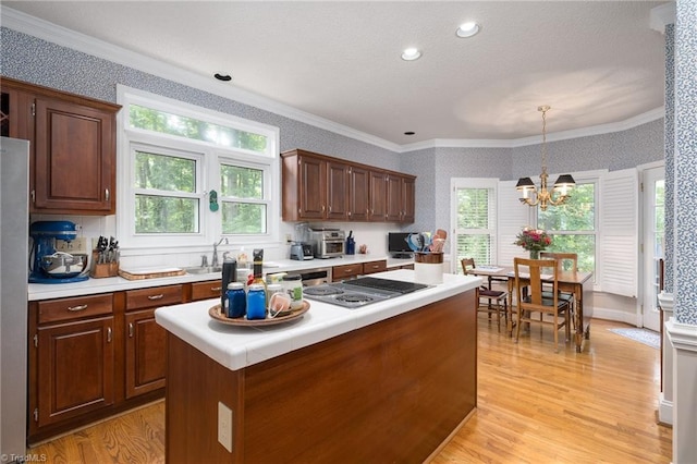 6516 Dornoch Dr, Greensboro, NC 27410 - kitchen with wallpapered walls, light countertops, ornamental molding, light wood-type flooring, and a center island